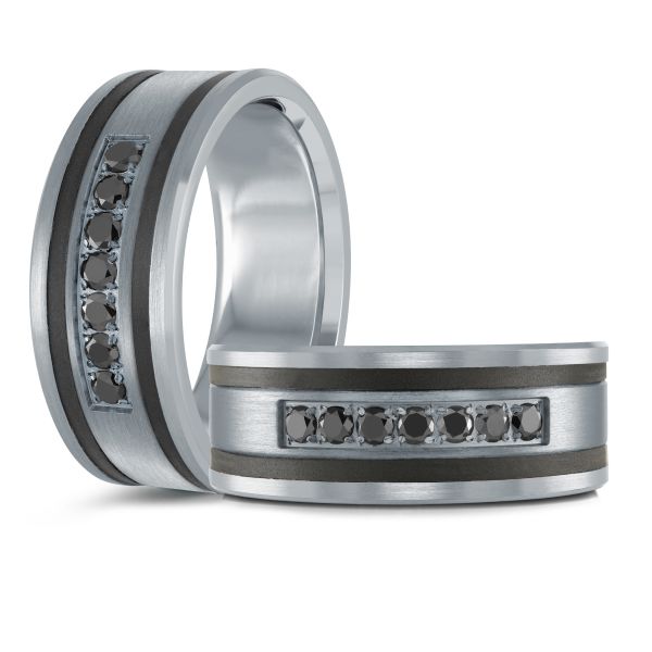 Two black ceramic wedding bands with brushed silver inlays and black diamonds, on a white background.