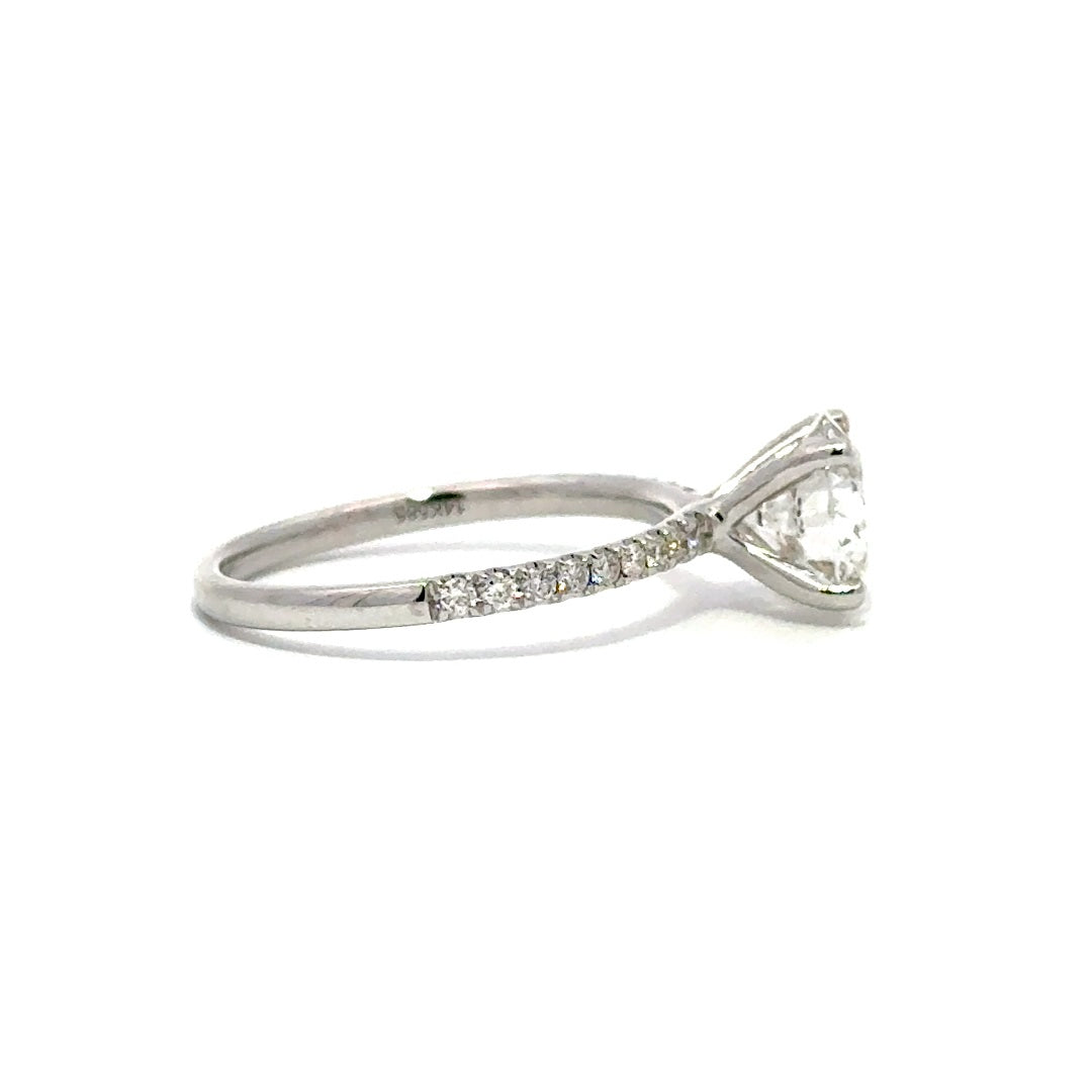 Silver gold solitaire engagement ring with a round cut diamond center stone on a white background.