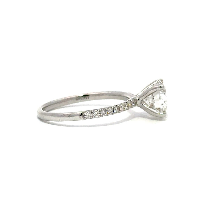 Silver gold solitaire engagement ring with a round cut diamond center stone on a white background.