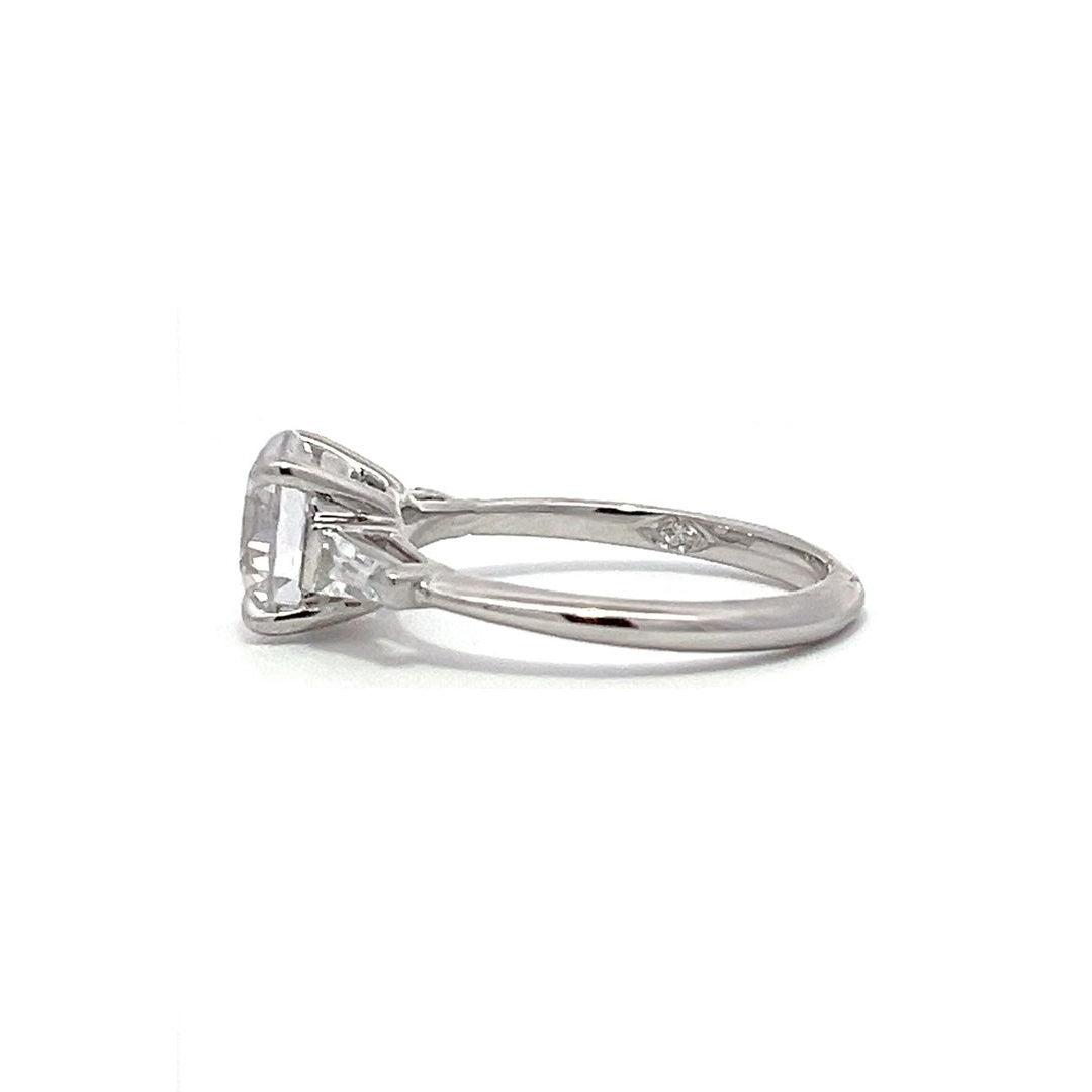 White gold three-stone diamond engagement ring with round-cut center stone and baguette side stones on a white background.
