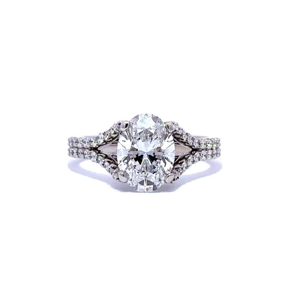 Silver engagement ring with an oval-cut diamond center stone and split diamond bands, on a white background.