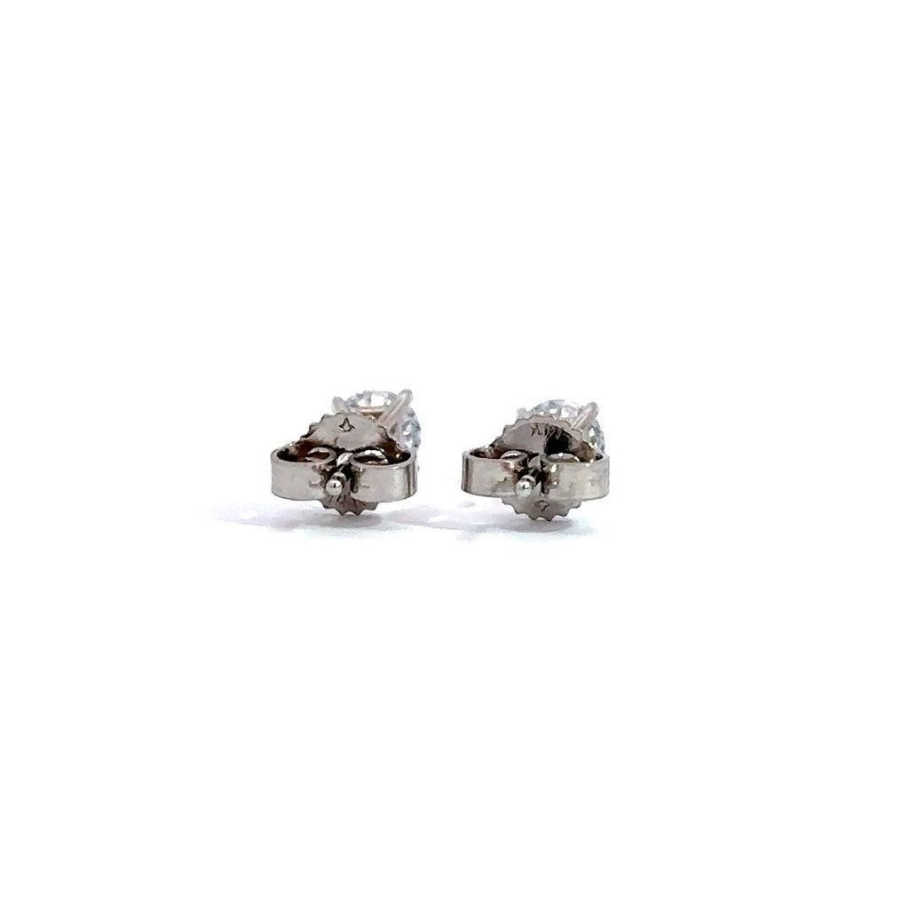 Pair of white gold stud earrings with a triangular setting of diamonds on a white background.