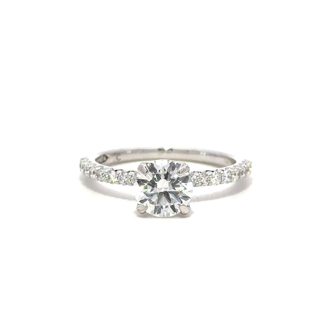 Front view of a silver engagement ring with a round-cut center diamond.