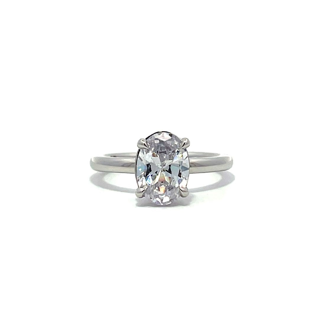 White gold oval diamond solitaire engagement ring on a white background.