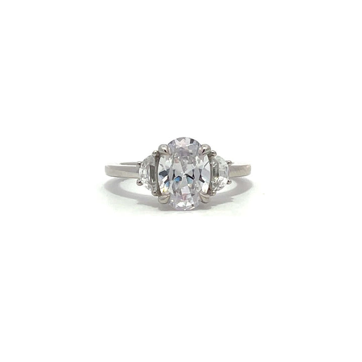 White gold three-stone diamond engagement ring with pear-shaped side stones on a white background.