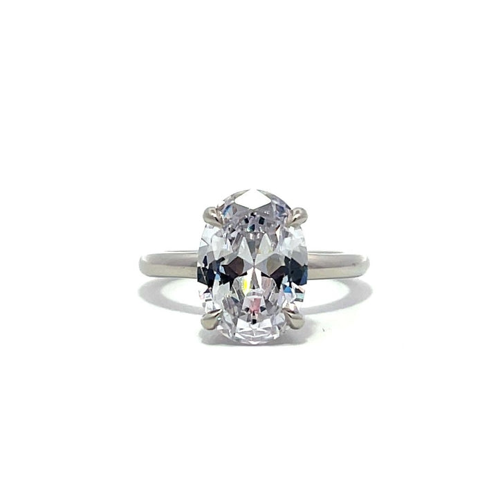 White gold oval diamond solitaire engagement ring on a white background