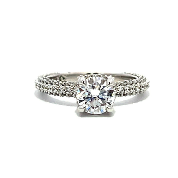 White gold round-shaped diamond engagement ring with a diamond band on a white background.