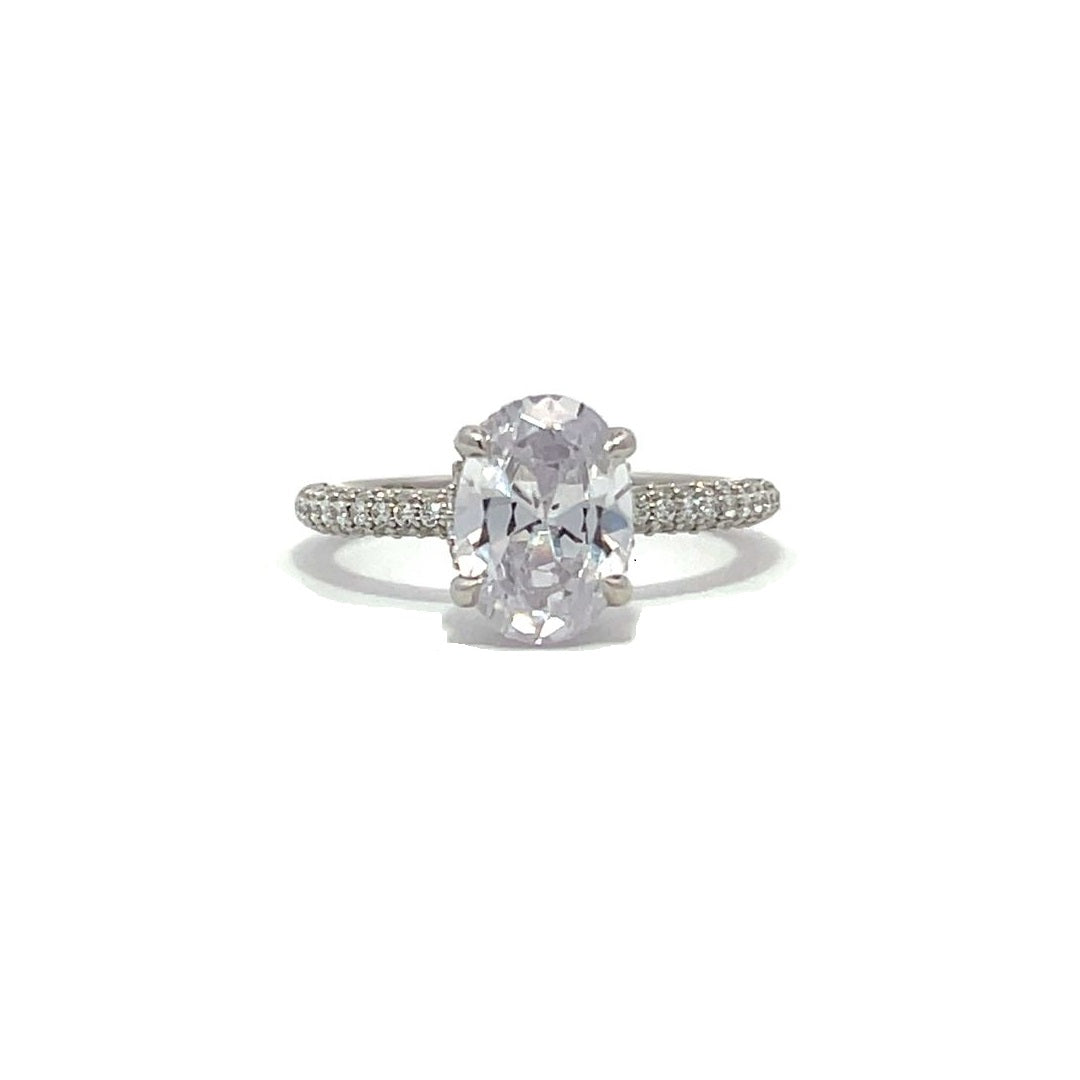 White gold oval-shaped diamond engagement ring with a diamond band on a white background.