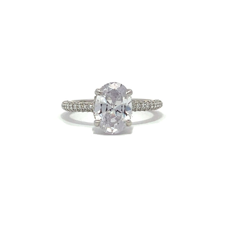 White gold oval-shaped diamond engagement ring with a diamond band on a white background.