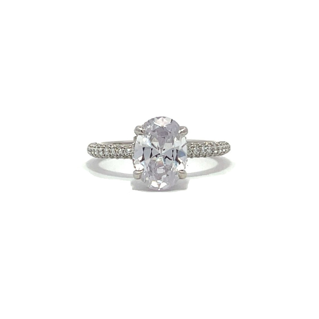 White gold oval-shaped diamond engagement ring with a diamond band on a white background.