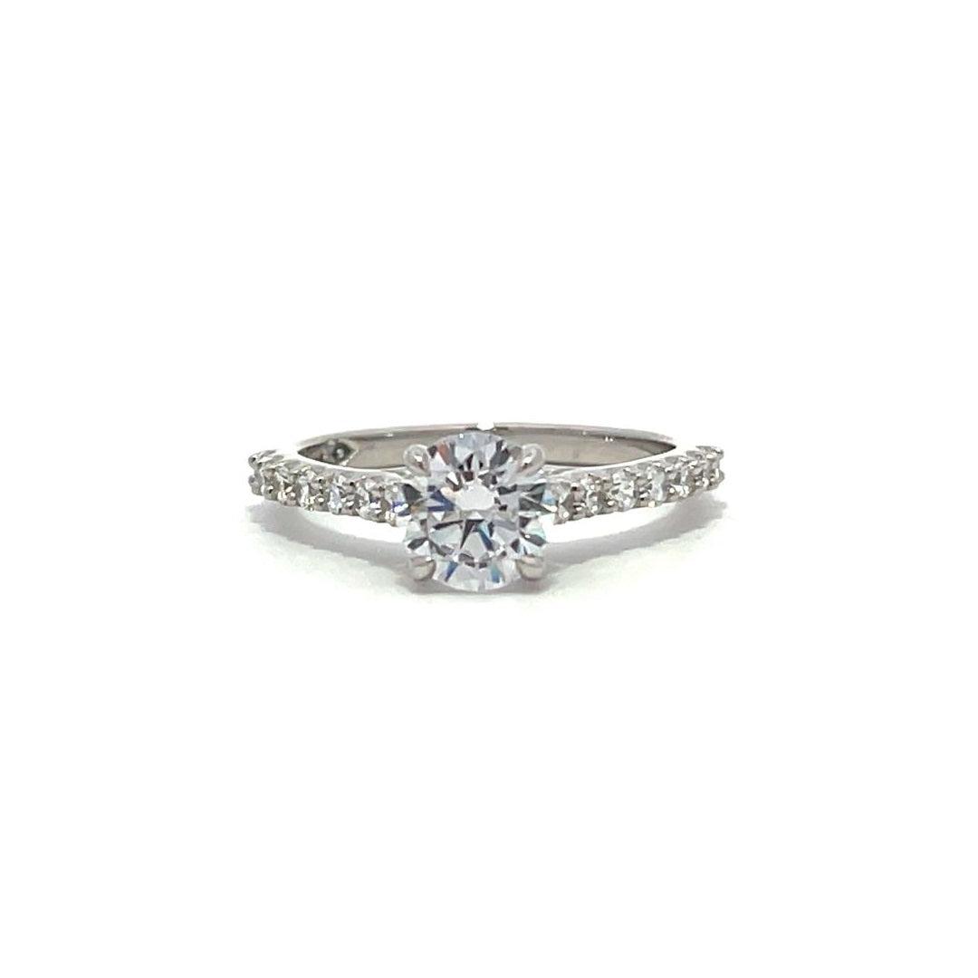 White gold round-shaped diamond engagement ring with a diamond band on a white background.