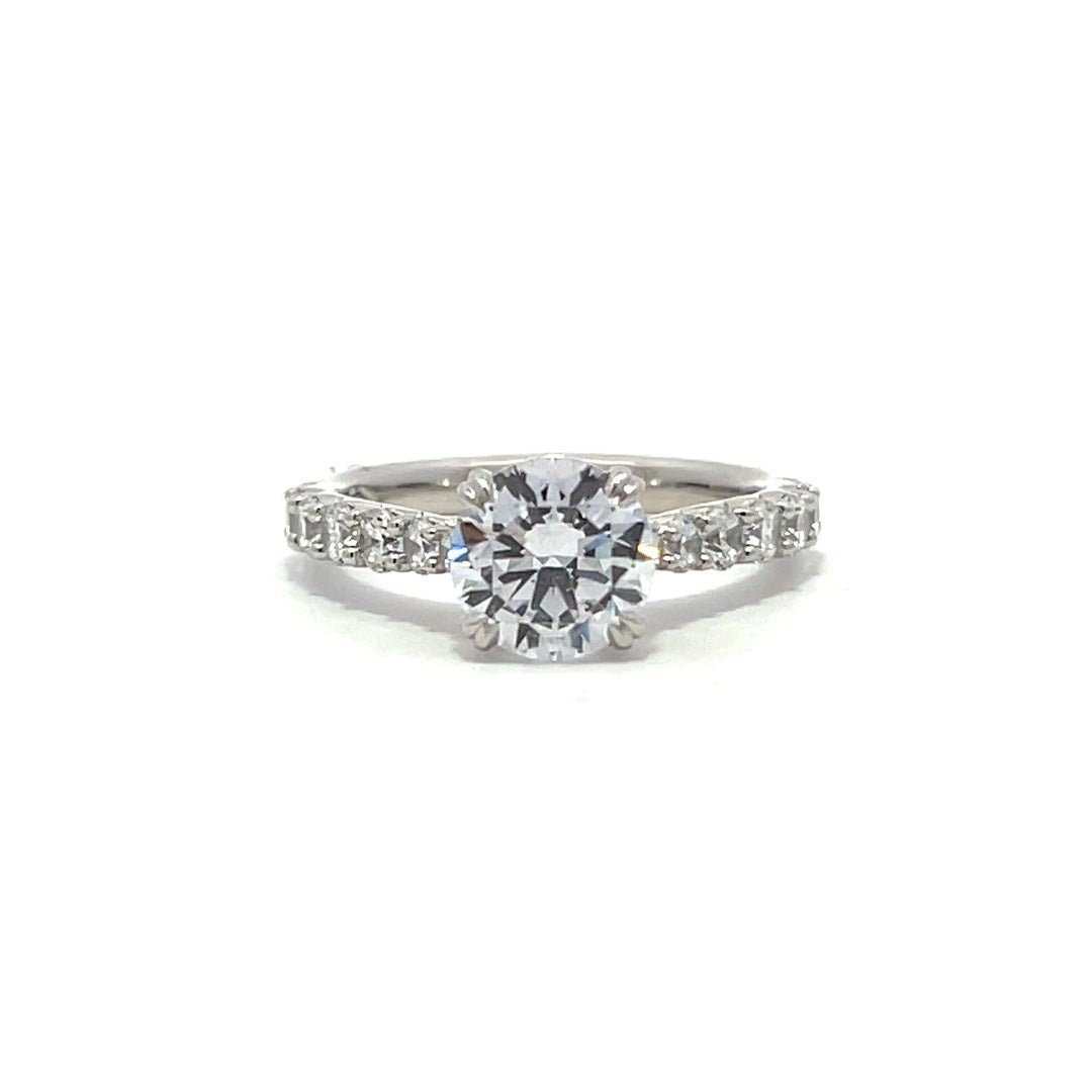 White gold round-shaped diamond engagement ring with a diamond band on a white background.