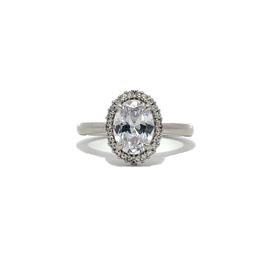 White gold oval diamond engagement ring with a halo setting on a white background