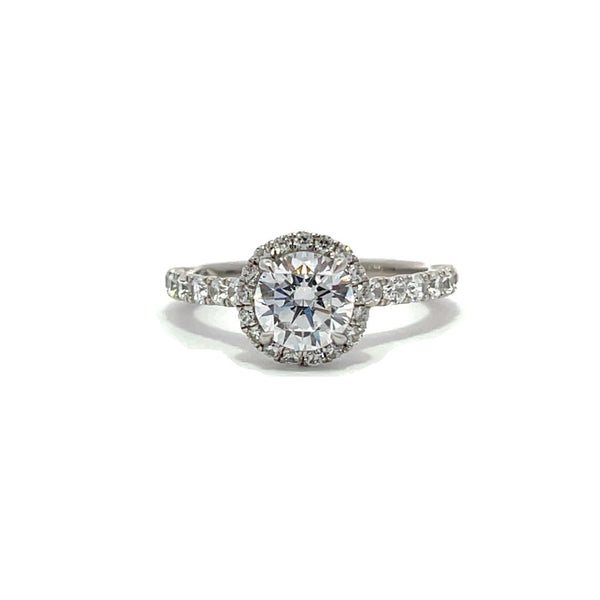 Silver engagement ring with a diamond halo setting and a diamond band on a white background