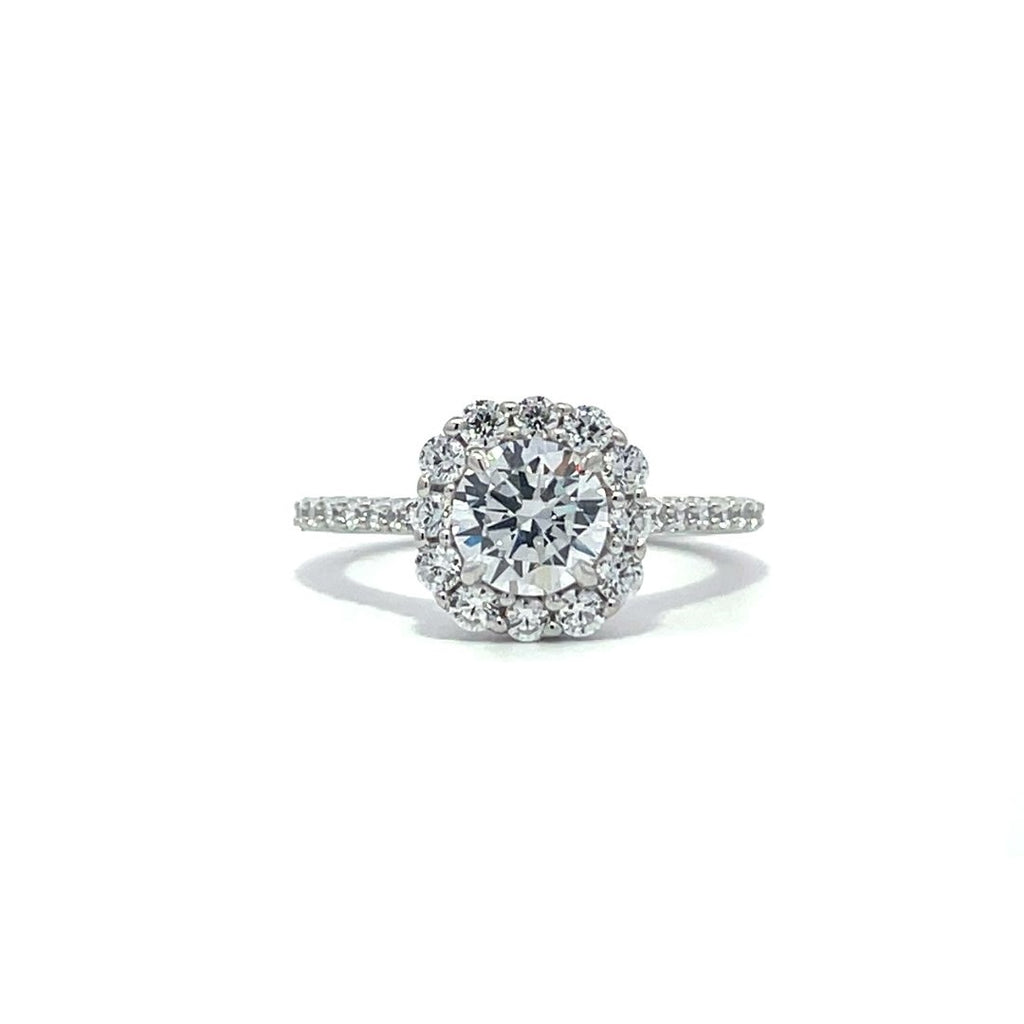 Silver engagement ring with a diamond halo setting and a diamond band on a white background