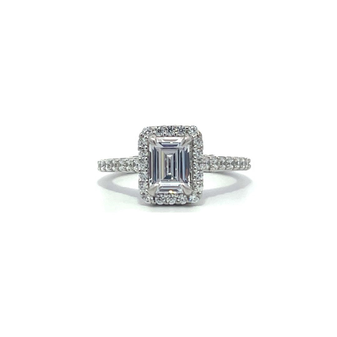 Silver emerald-cut engagement ring with a double halo setting on a white background