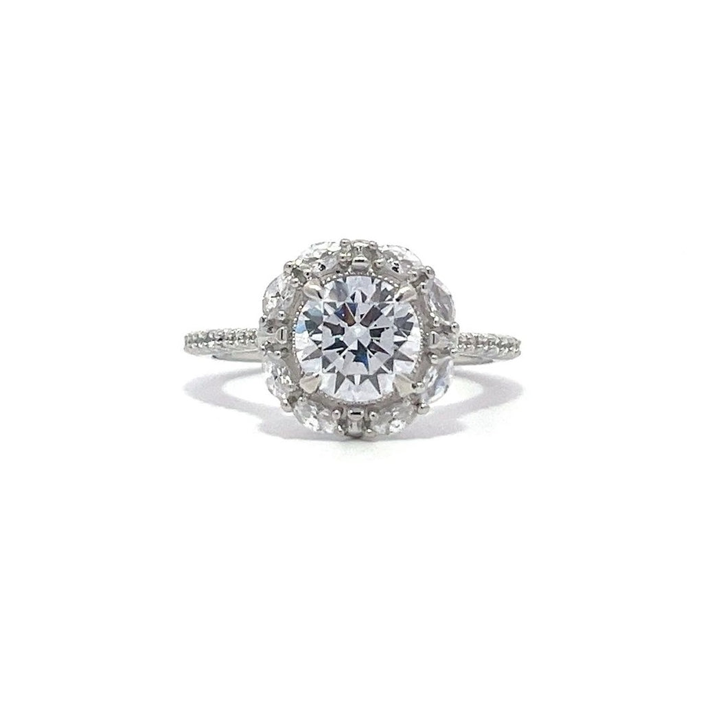 Silver engagement ring with a diamond halo setting and a diamond band on a white background