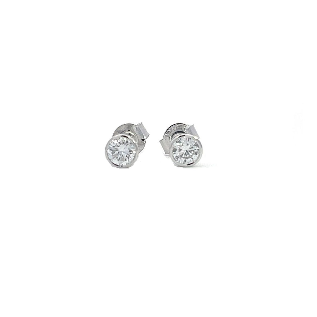 White gold stud earrings with round diamonds in  bezel setting on a white background.