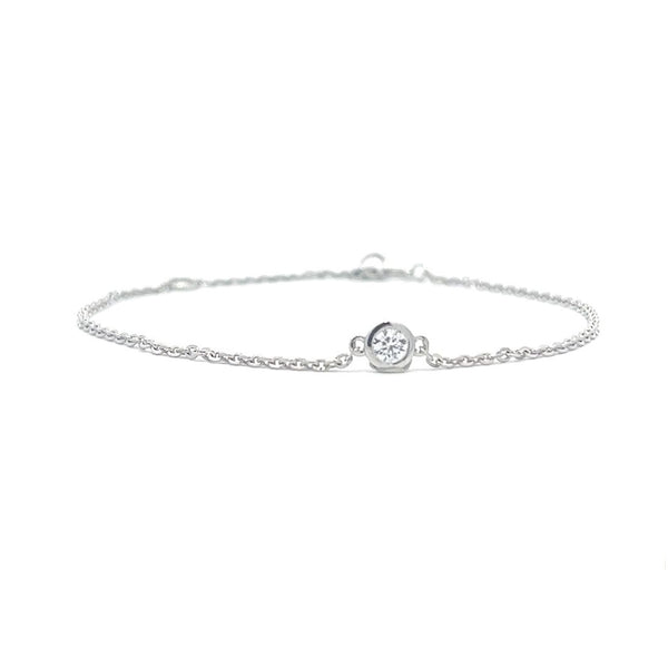 Silver bracelet with a single diamond pendant on a white background.