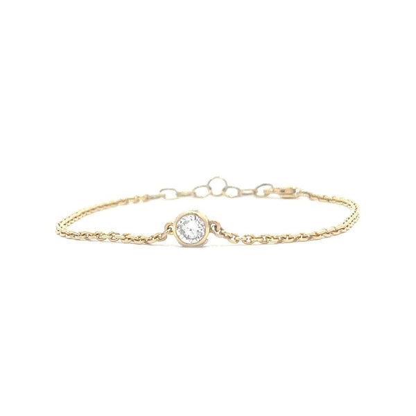 Yellow gold bracelet with a single diamond pendant in a bezel set on a white background.