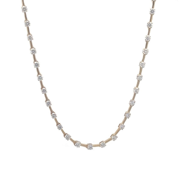 Yellow gold necklace with a row of round diamonds on a white background.