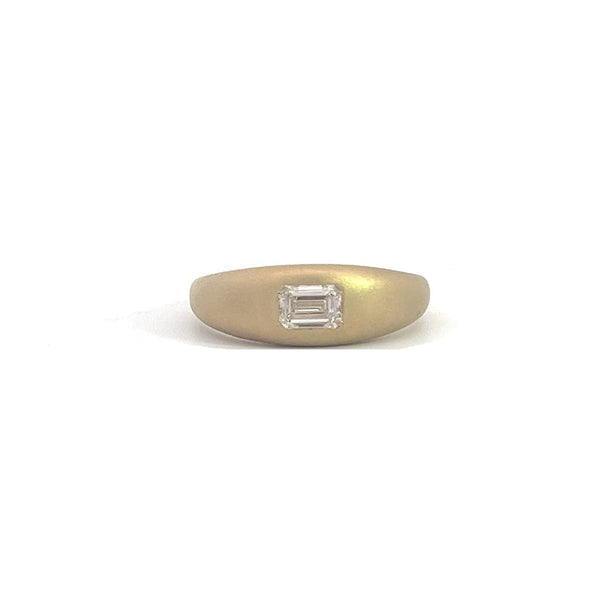 Yellow gold ring with an emerald-cut diamond set in a matte gold band, on a white background.