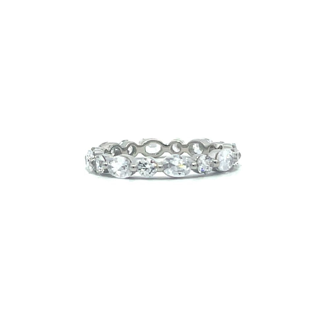 Silver eternity ring with oval and round stones on a white background.