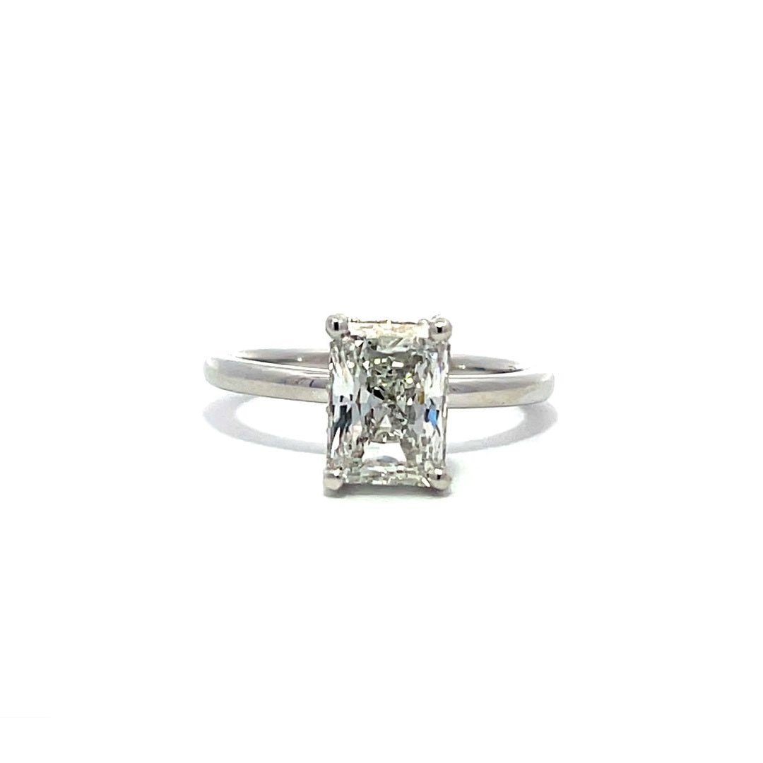 White gold engagement ring with a radiant-cut diamond center stone on a white background.