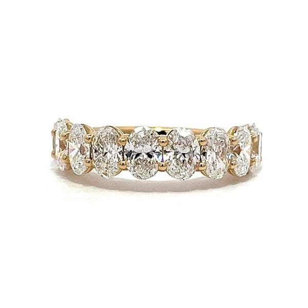 Yellow gold eternity band with oval-shaped diamonds on a white background.