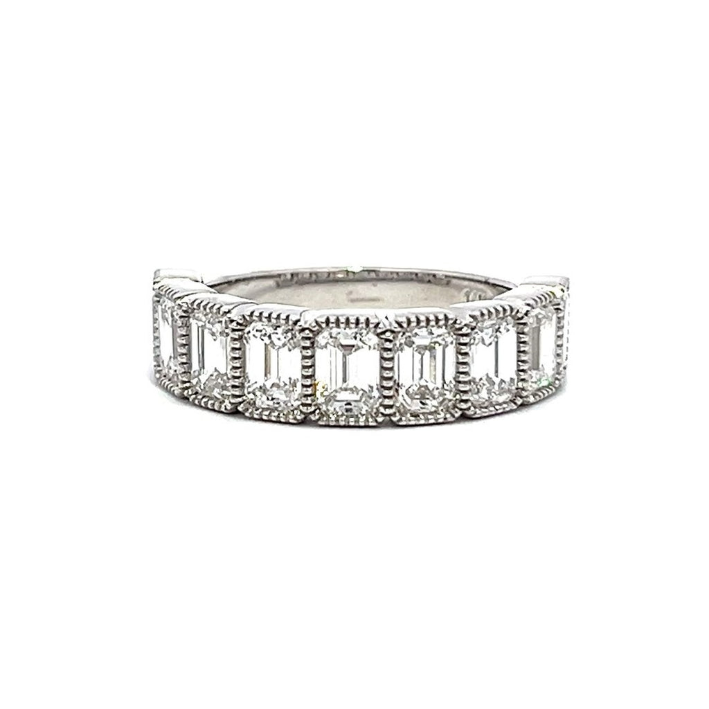 White gold eternity band with bezel-set emerald diamonds on a white background.