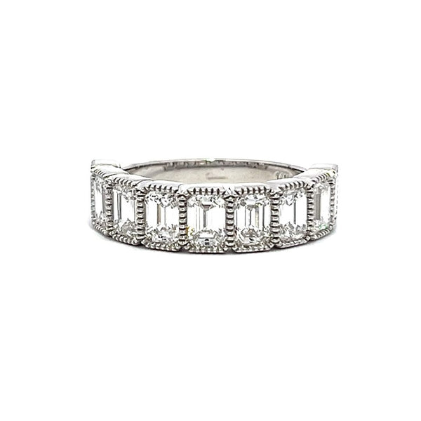 White gold eternity band with bezel-set emerald diamonds on a white background.