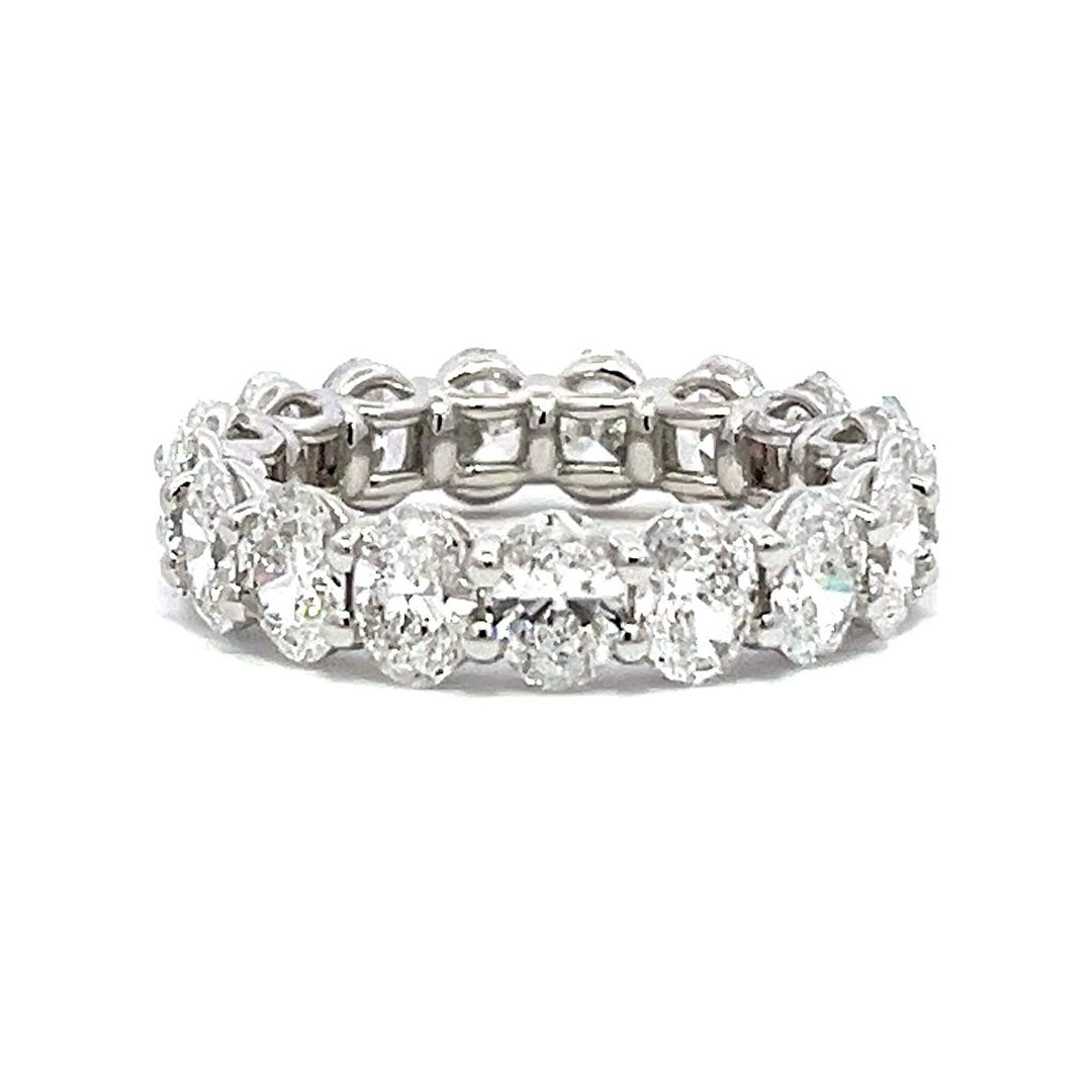 Silver eternity band with oval-shaped diamonds on a white background.