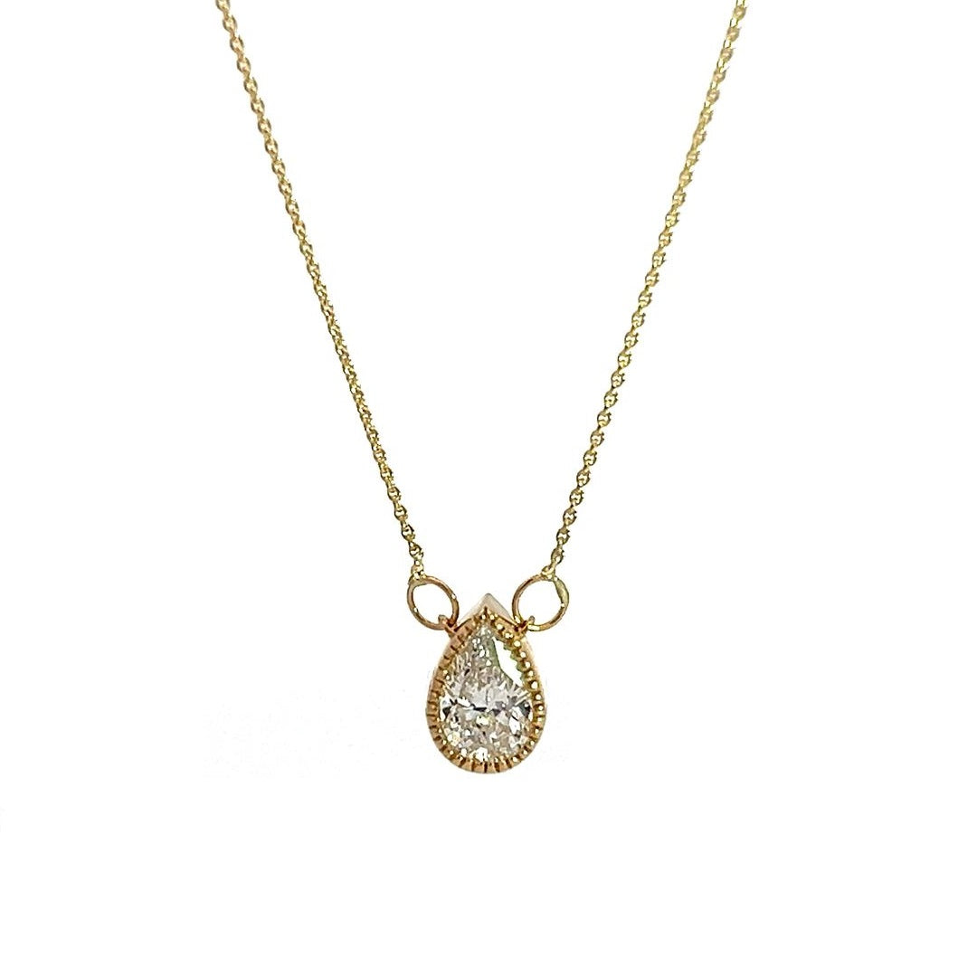  Yellow gold necklace with a pear-shaped diamond pendant on a white background.