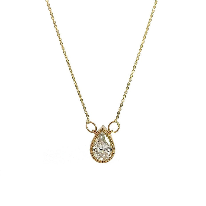  Yellow gold necklace with a pear-shaped diamond pendant on a white background.