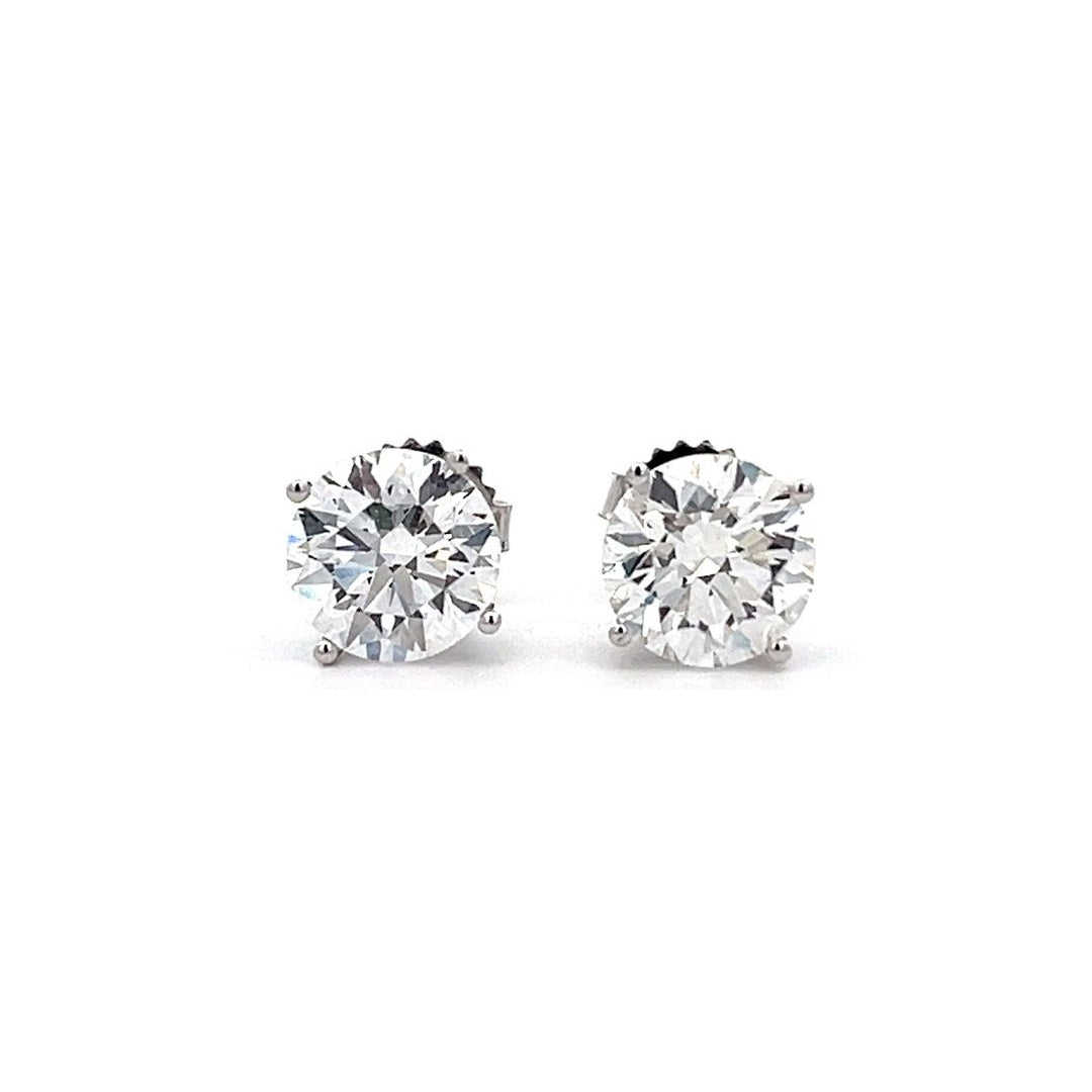 White gold stud earrings with round diamonds on a white background.