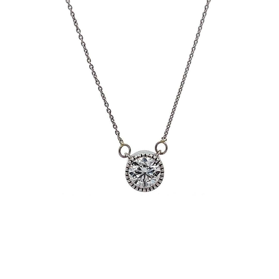 White gold necklace with a round diamond solitaire pendant on a white background.