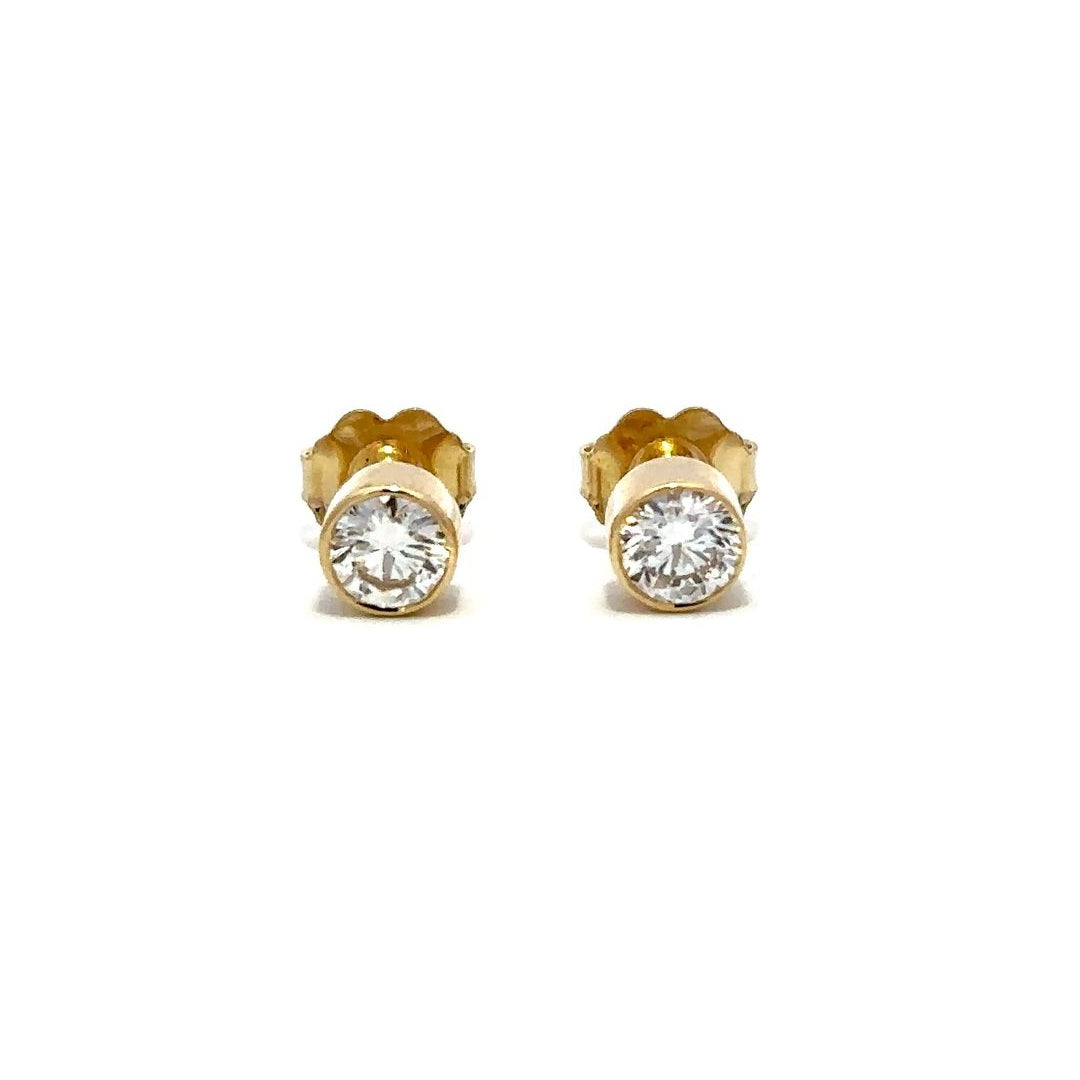 Yellow gold diamond stud earrings on a white background