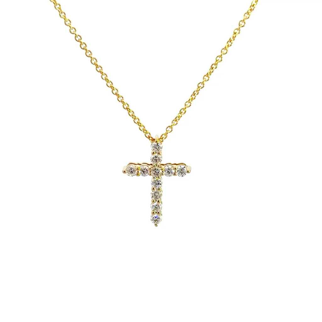 Yellow gold diamond cross necklace on a white background