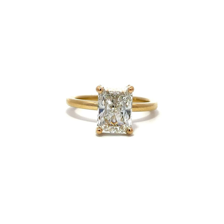 Yellow gold engagement ring with a diamond halo setting on a white background