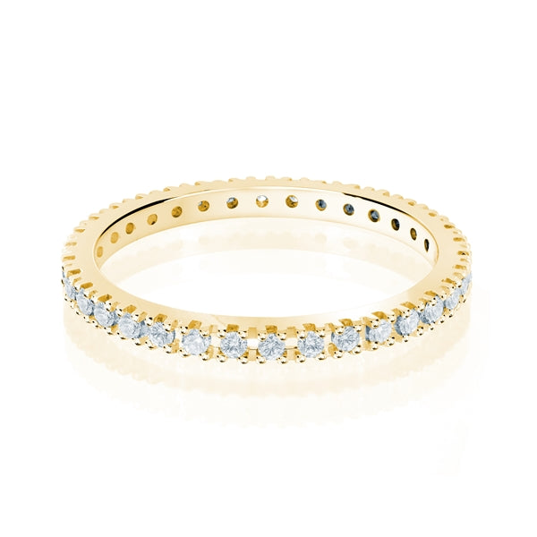 Yellow gold wedding band with diamond accents on a white background.