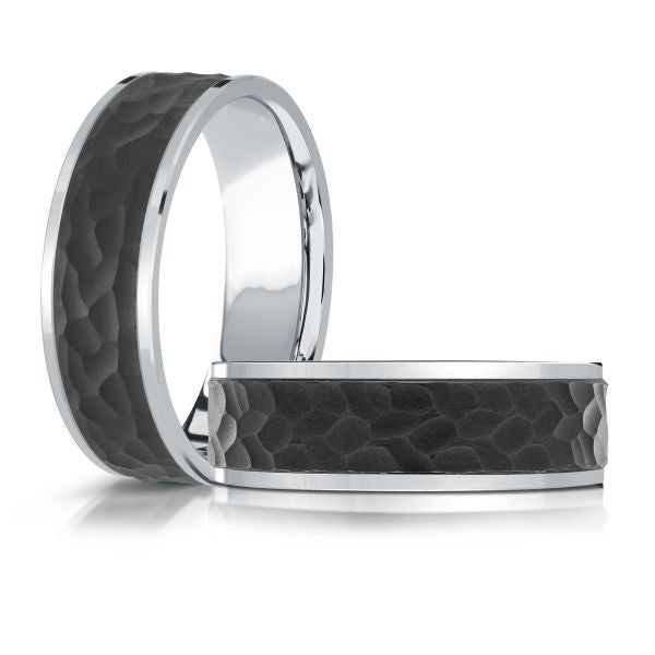 Black ceramic wedding band with a hammered finish and a polished white gold edge, on a white background.