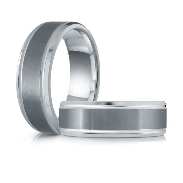 Two brushed tungsten wedding bands with a white gold inlay on a white background.