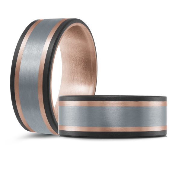 Black ceramic wedding band with a rose gold interior and a brushed silver inlay on a white background