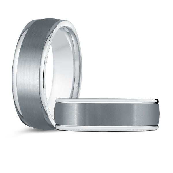 Two tungsten wedding bands with white gold inlay on a white background