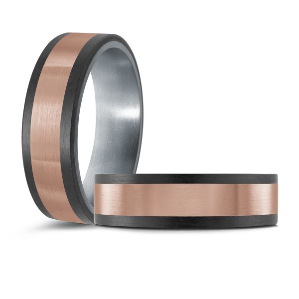 Black ceramic wedding band with a rose gold inlay on a white background