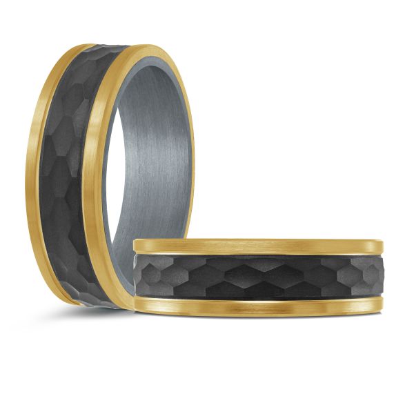 Black ceramic wedding band with a yellow gold inlay on a white background