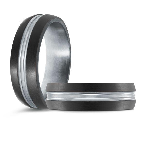 Black ceramic wedding band with a white gold inlay on a white background