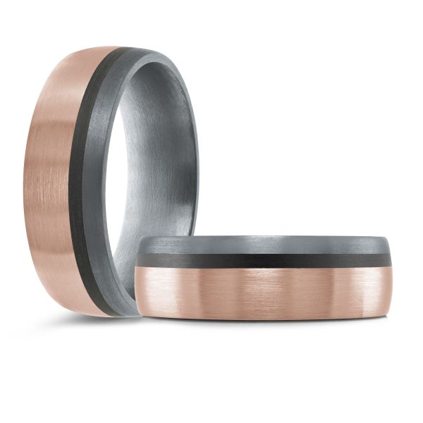 Black ceramic wedding band with a rose gold inlay on a white background