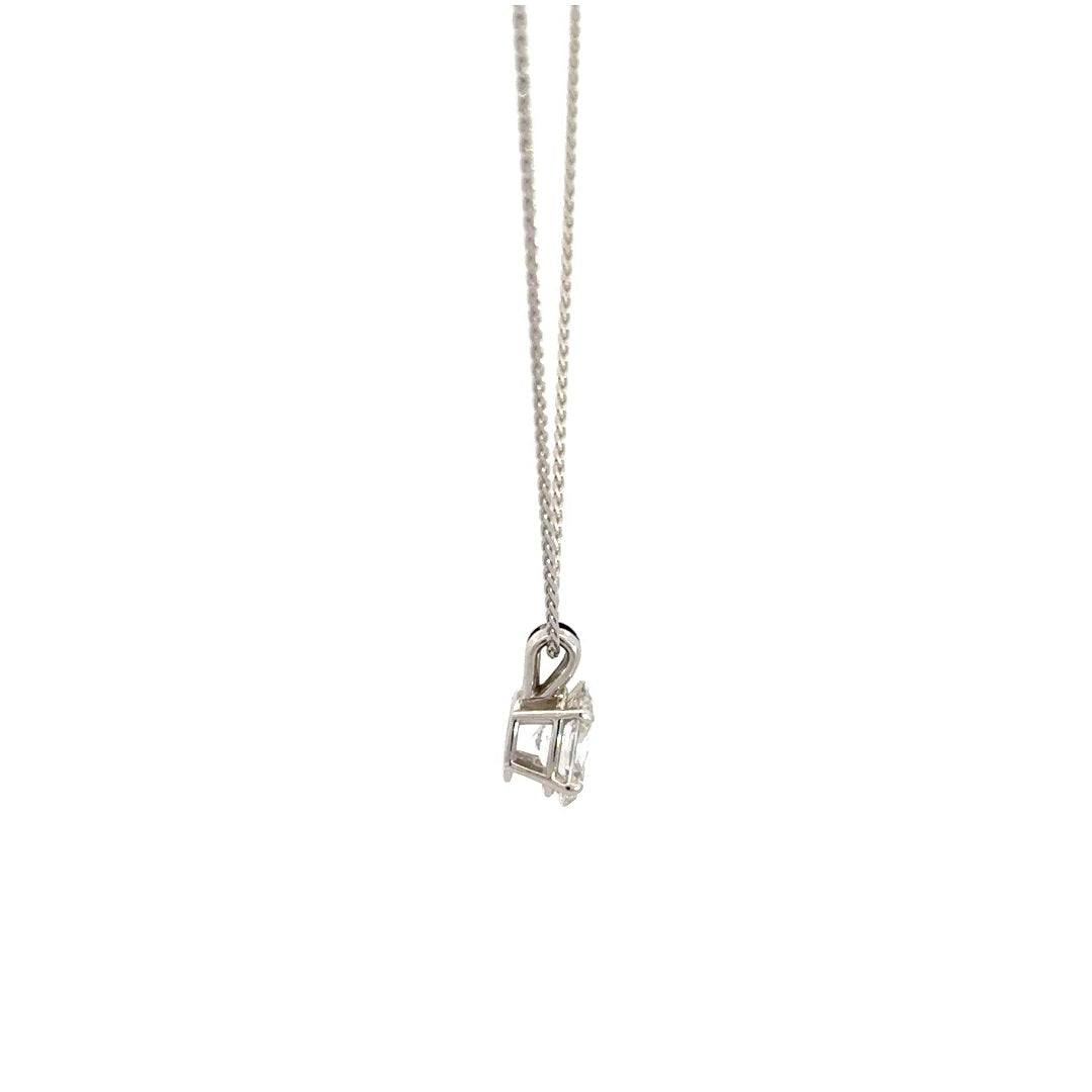 Side view of silver necklace with a oval-cut diamond in a four-prong setting pendant on a white background.