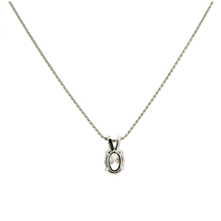 Back view of silver necklace with a oval-cut diamond in a four-prong setting pendant on a white background.